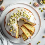 Pistachio Bundt Cake: Moist, Nutty & Nostalgic Treat You’ll Love Pistachio Bundt Cake Top view of a homemade pistachio bundt cake with white vanilla glaze and chopped pistachios, sliced and served on plates